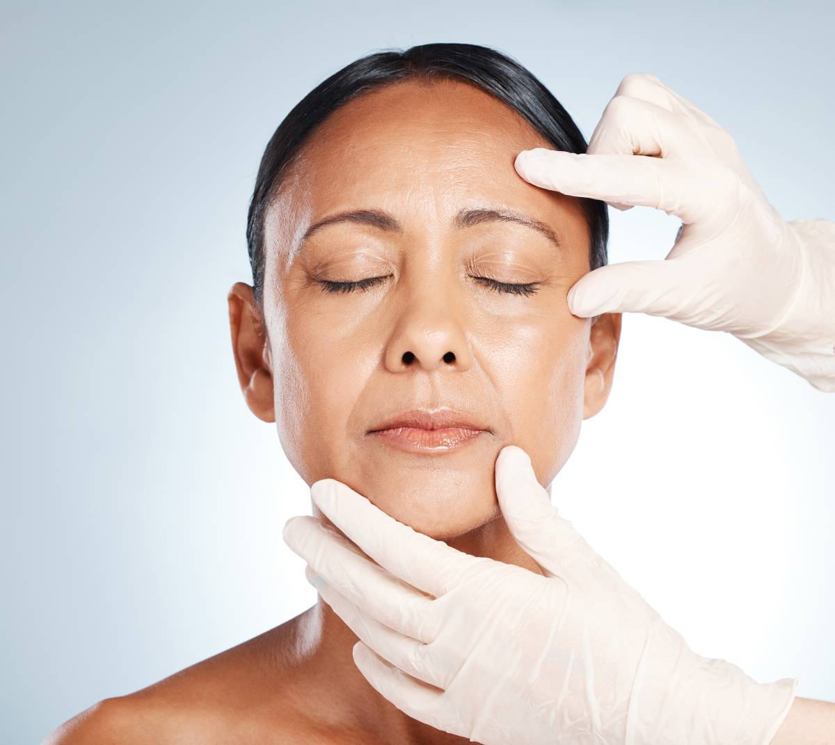Doctor's hands check face for plastic surgery and beauty consultation