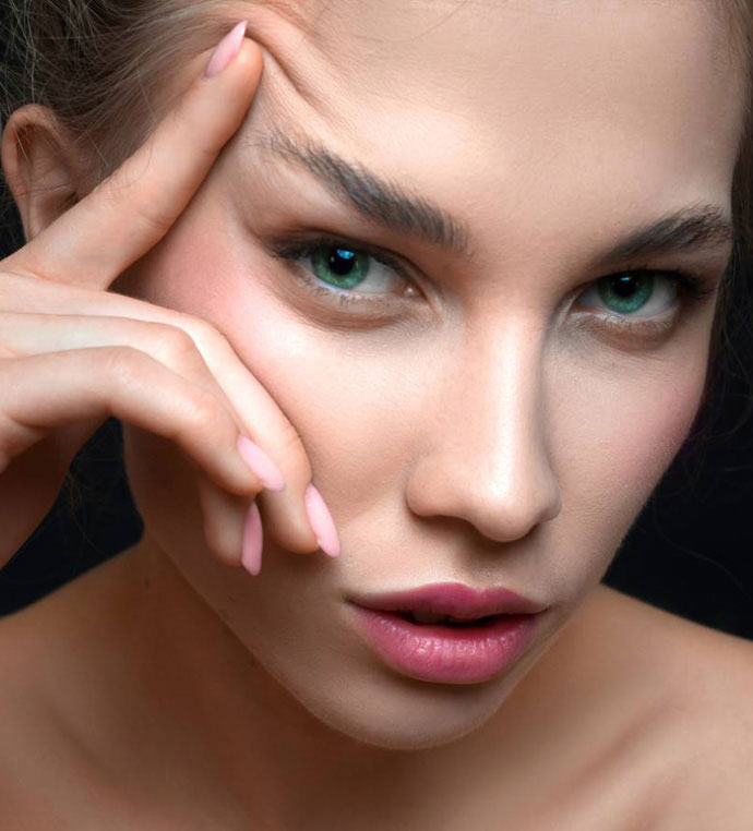 stock image of beautiful woman touching her eyebrow