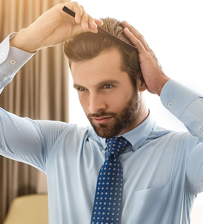 stock image of model combing his hair on formal dress